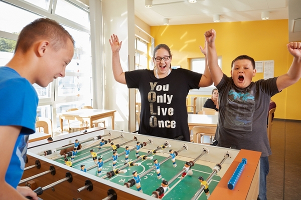 Drei Kinder spielen Tischfußball. Drei Kinder spielen Tischfußball.