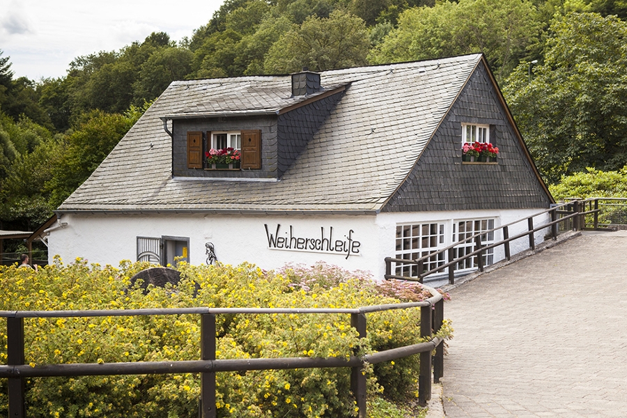 Das Haus Weiherschleife steht vor einem Wald. Das Haus Weiherschleife steht vor einem Wald.