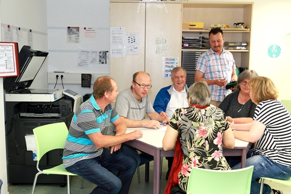 Lehrerinnen und Lehrer sitzen an einem Tisch und tauschen sich gegenseitig aus.