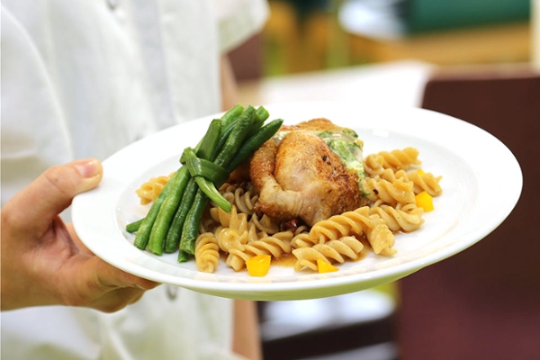 Grüner Spargel mit Fleisch und Nudeln auf einem angerichteten Teller Grüner Spargel mit Fleisch und Nudeln auf einem angerichteten Teller
