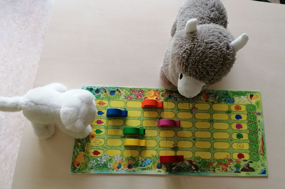 Zwei Stofftiere vor einem Brettspiel Zwei Stofftiere vor einem Brettspiel