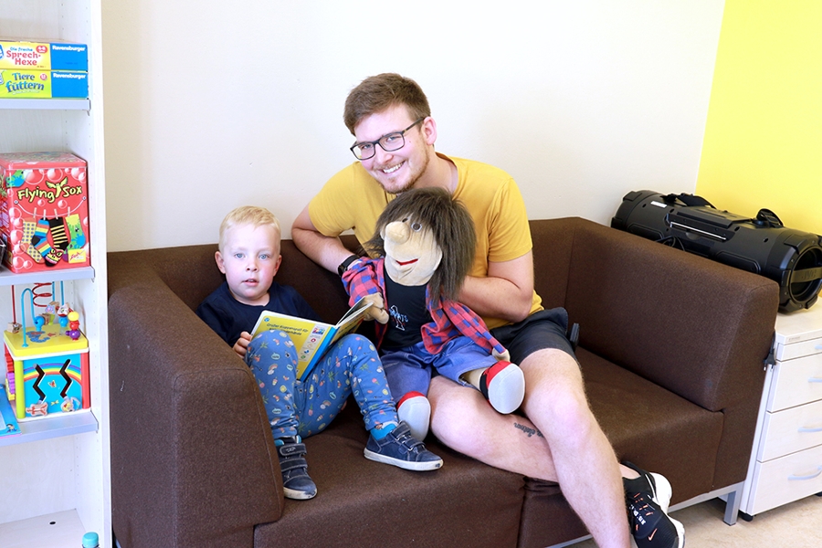 Logopäde Lukas Barth und junger Patient mit Handpuppe