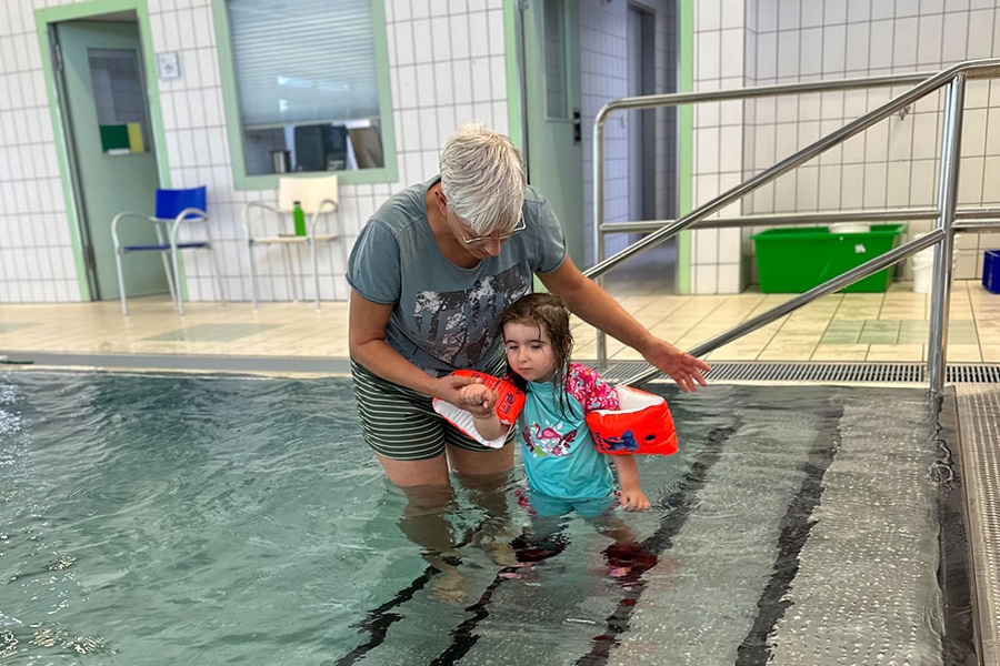 Sarah Schulze mit ihrer Therapeutin beim Gehtraining auf den Stufen eines Schwimmbeckens Sarah Schulze mit ihrer Therapeutin beim Gehtraining auf den Stufen eines Schwimmbeckens