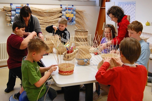 Mütter und Kinder beim Korbflechten